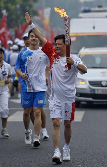 图文-奥运圣火在北京首日传递 火炬手王卫民