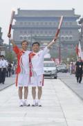 图文-奥运圣火在北京首日传递 两名火炬手在交接