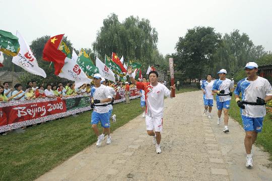 图文-奥运圣火在北京传递第2日 闫琪手持火炬传递
