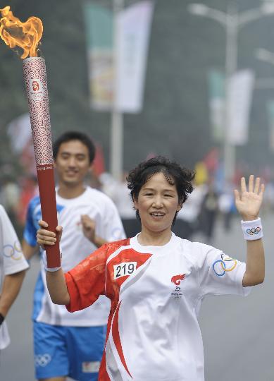 图文-奥运圣火在北京传递第2日 王桂民手持火炬传递