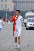 图文-奥运圣火在北京进行首日传递 信兰成跑步