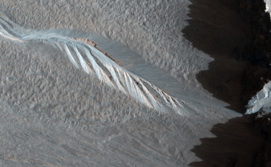 处于“西霍尔陨石坑”（Western Hale Crater）内壁的溪谷，笼罩在高耸的陨石坑边缘的阴影下。