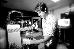 工作人员正在蓝色幽暗的“车间”内操作检测设备