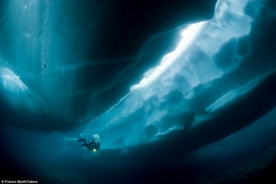 摄影师弗朗克-班菲潜入冰川下方，勘探冰融后形成的通道和洞穴
