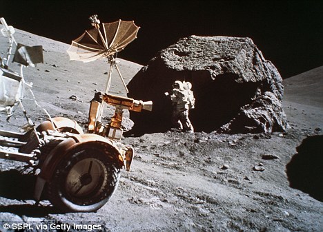 从这张照片上可以看到，施密特正在一块巨石旁收集月球岩石样本，月球车的部分出现在他前面的画面上