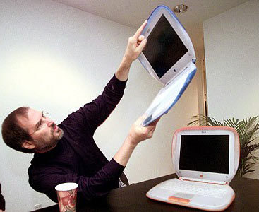 乔布斯1999年7月21日在Macworld大展上发表了主题演讲。图为乔布斯手持iBook，该产品售价为1599美元，有橘色和蓝色两种颜色可选。