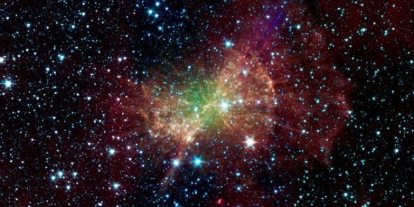 美国宇航局斯皮策太空望远镜拍摄的这张图片，显示的是哑铃星云发射出大量红外辐射。这个“行星状星云”被它中心的死亡恒星的内核照亮