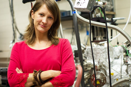 物理系研究生Charlotte Sanders参与了世界最小纳米激光发射器的研发工作。她身边的分子束外延机正是由她自己设计、并在Jisun Kim博士的协助下建造而成。这台机器用于制造发射器中最为关键的银薄层。图片来源：Alex Wang.