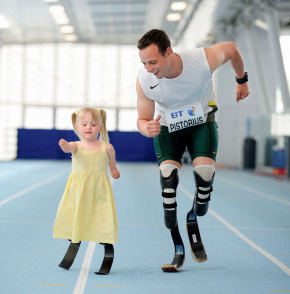 2009 年 5 月 17 日，英国，奥斯卡在教 5 岁的小女孩 Ellie Challis 用假肢走路