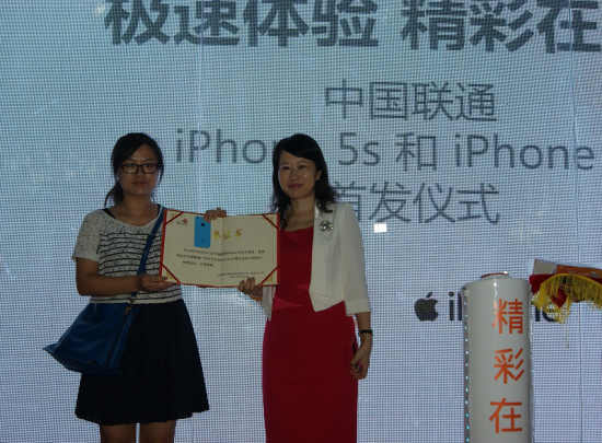 ，广东联通副总经理周立松（右）为第一位iPhone5c用户颁发荣誉证书及纪念品