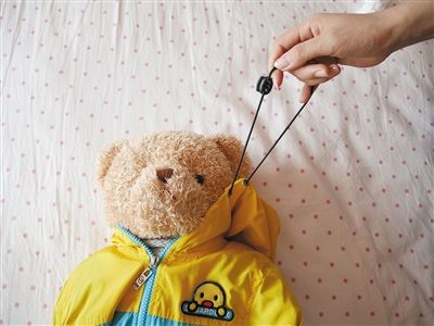 9月2日，记者尝试拉扯一件套在玩具熊上童装的松紧带，拉出长度足够套住玩具熊的头。
