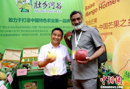 图为国外客商参观芒果展区。 杨志雄 摄