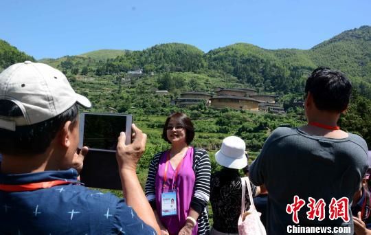 图为海外华文媒体代表与土楼群合影。 张金川 摄 图为海外华文媒体代表与土楼群合影。 张金川 摄