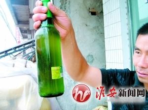 高先生手里的这瓶啤酒里有不明漂浮物 李蓉 摄