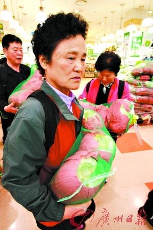 9日，人们在韩国首尔一家超市排队购买中国白菜。(图片来源： 广州日报)
