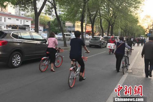 北京街道上正在骑共享单车的人。 官方共享单车发展政策征意见:7规定不知道会吃亏