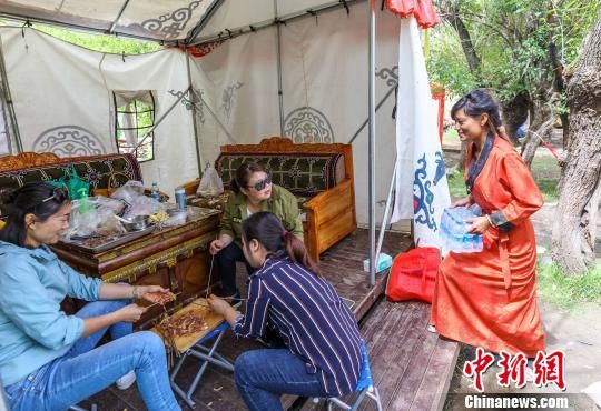到达东过林卡已成为拉萨市民最喜爱的休闲度假方式,茶果在给客人送矿泉水。 域上和美集团 供图 西藏文化旅游产业带动西藏百姓就地脱贫