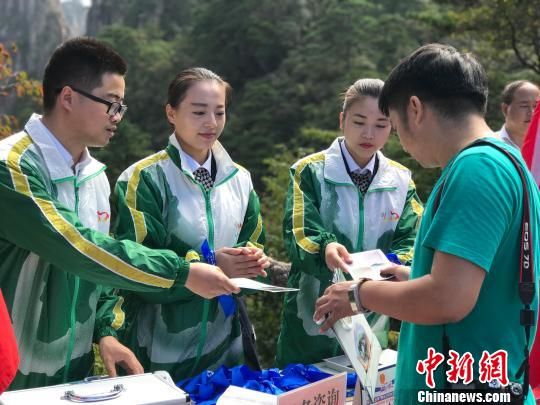 志愿者向游客发放垃圾袋和蓝丝带 侯晏 摄 安徽黄山风景区国庆期间倡导游客环保出行
