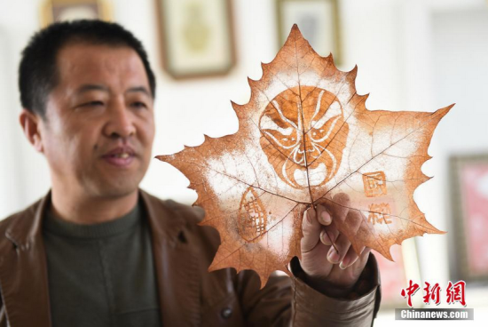 一片普通叶子在手工艺人的精雕细琢下,精美的图案就跃然而上。 郭宏伟 摄 山西襄垣民间艺人树叶上雕出斑斓世界