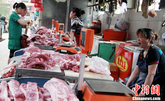 7月5日中午，北京一菜市场的猪肉摊位门庭冷落，前来买肉的市民寥寥无几，有的摊主已经困的打起了哈气。中新社发 翟羽佳 摄