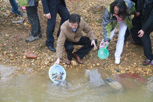 局长王晓峰在将鱼放回到湖水中 鄱阳湖放生 江西旅游经济步步高
