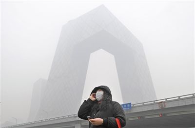 2013年1月29日，东三环光华桥下，央视大楼在大雾中隐隐约约。今年，北京将调整部分大额专项资金，拿出12.5亿元用于备受关注的大气污染治理。 新京报记者 陈杰 摄