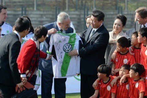 2014年3月29日，柏林奥林匹亚体育场足球场，习近平和夫人彭丽媛与中国少年足球运动员及共同训练的沃尔夫斯堡足球俱乐部少年队员合影。