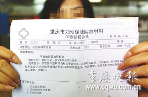 医院的诊断报告单显示,汪妻子宫内有根手术导管. 记者 杨帆 摄