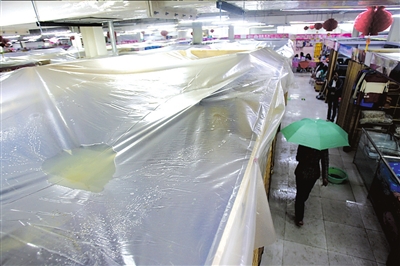 楼顶漏水商户扯塑料布遮雨