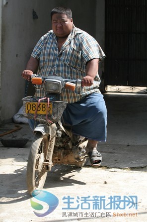 李根户骑摩托车时,整辆摩托车全被他胖胖的身