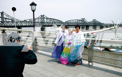 丹东:鸭绿江边穿着朝鲜族服装留影的游客(王年