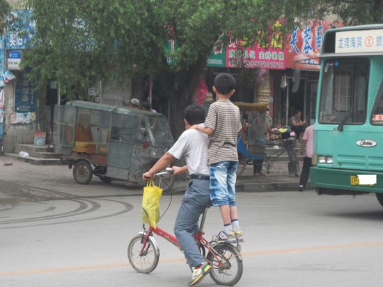 男子骑自行车带小孩马路上表演“车技”险被撞