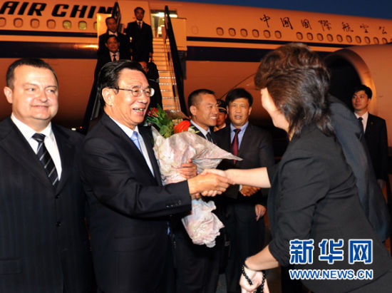  7月10日，中共中央政治局常委、中央纪委书记贺国强抵达贝尔格莱德，开始对塞尔维亚进行正式友好访问。这是使馆工作人员向贺国强敬献鲜花。新华社记者李涛摄