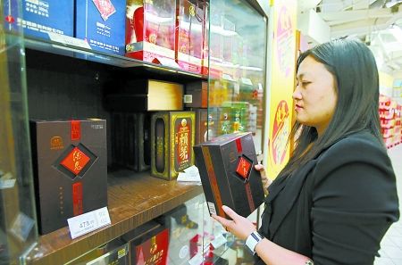 昨日，上海一家超市工作人员正下架系列酒鬼酒产品。新华社图