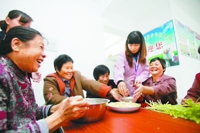社区居家养老服务站人员和老人们一起包饺子