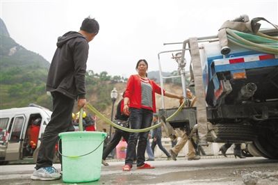 4月22日，宝兴县，灾民在应急供水车前打水。 新京报记者 侯少卿 摄