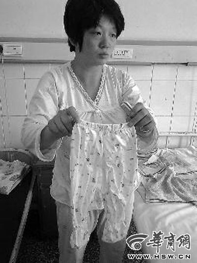 7月24日下午，失去孩子的董女士从病房柜子里拿出为儿子准备的一条裤子 本报记者 贾凡 摄