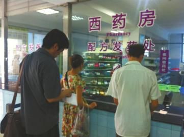 成都市卫生局中医处处长卢洪岩(左一)在等待取药。 成都市卫生局中医处处长卢洪岩(左一)在等待取药。