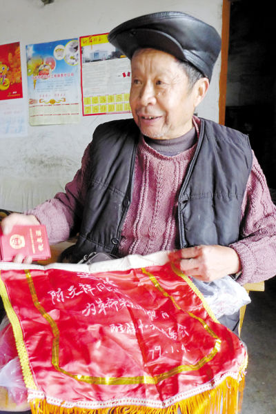 什邡市年龄最大的独生子女父母、74岁的陈天祥展示他当年的“计生模范”锦旗