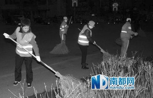3月22日，王桂芬(左一)在清扫马路，现场只有她未佩戴口罩。 图片来源：辽东网