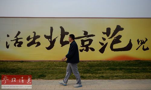 资料图片：2014年4月12日，在河北涿州市，一名市民从一处楼盘广告前走过。新华社记者 王晓 摄