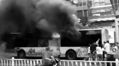 5日，公交车燃烧现场，路人砸车窗施救。视频截图