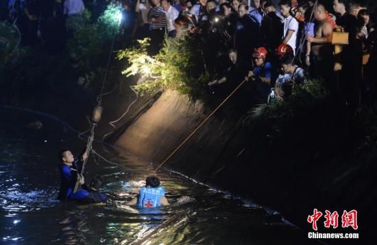 7月11日凌晨，消防官兵正在全力打捞落水校车。中新社记者 杨华峰 摄