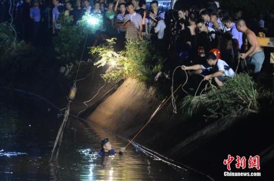 7月11日凌晨，消防官兵正在全力打捞落水校车。 中新社记者 杨华峰 摄