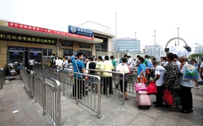 8月1日12时许，地铁北京站D口外，6个人工售票窗口开了4个，近百人排队购票。本版摄影/新京报记者 高玮