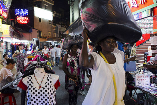 广州越秀小北地区宝汉直街，两个黑人妇女将采购的物品顶在头上，这是非洲妇女特有的持物方式。张新燕 澎湃资料 
