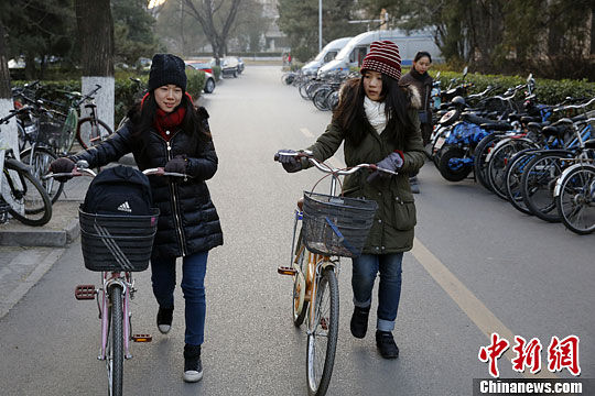 12月17日，北京大学泰国华裔留学生李慧敏（右）与白云莹在校园中。中新社 王骏 摄