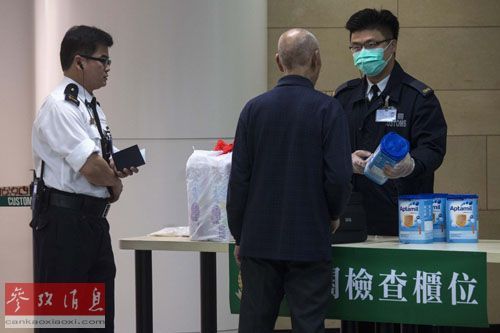 1月3日,香港海关人员盘查一名携带超量奶粉的男子.