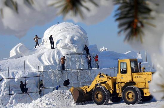 图文:铲车在雪雕作品旁作业