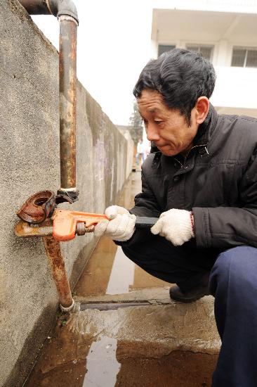 图文:广西资源水电工在修理被冻坏的自来水管